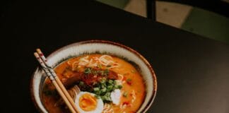 Ostry ramen w domu: bulion, makaron, chili i wszystkie dodatki jak z japońskiego baru Miska pikantnego ramenu z jajkiem, zieleniną i pałeczkami