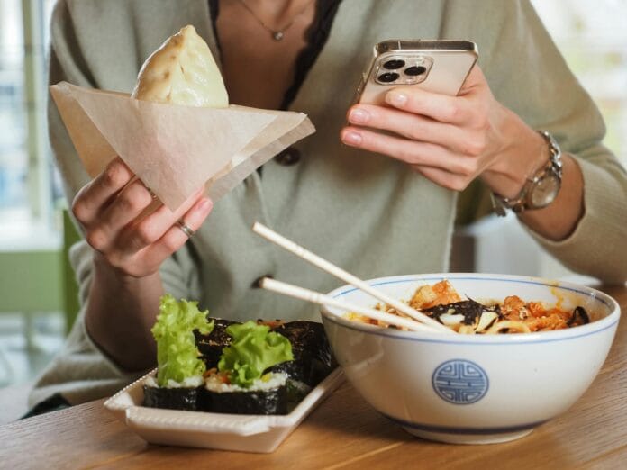 Osoba je bao w azjatyckiej restauracji, przeglądając telefon