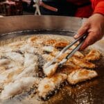 Empanadas smażące się w gorącym oleju, zbliżenie ulicznego jedzenia
