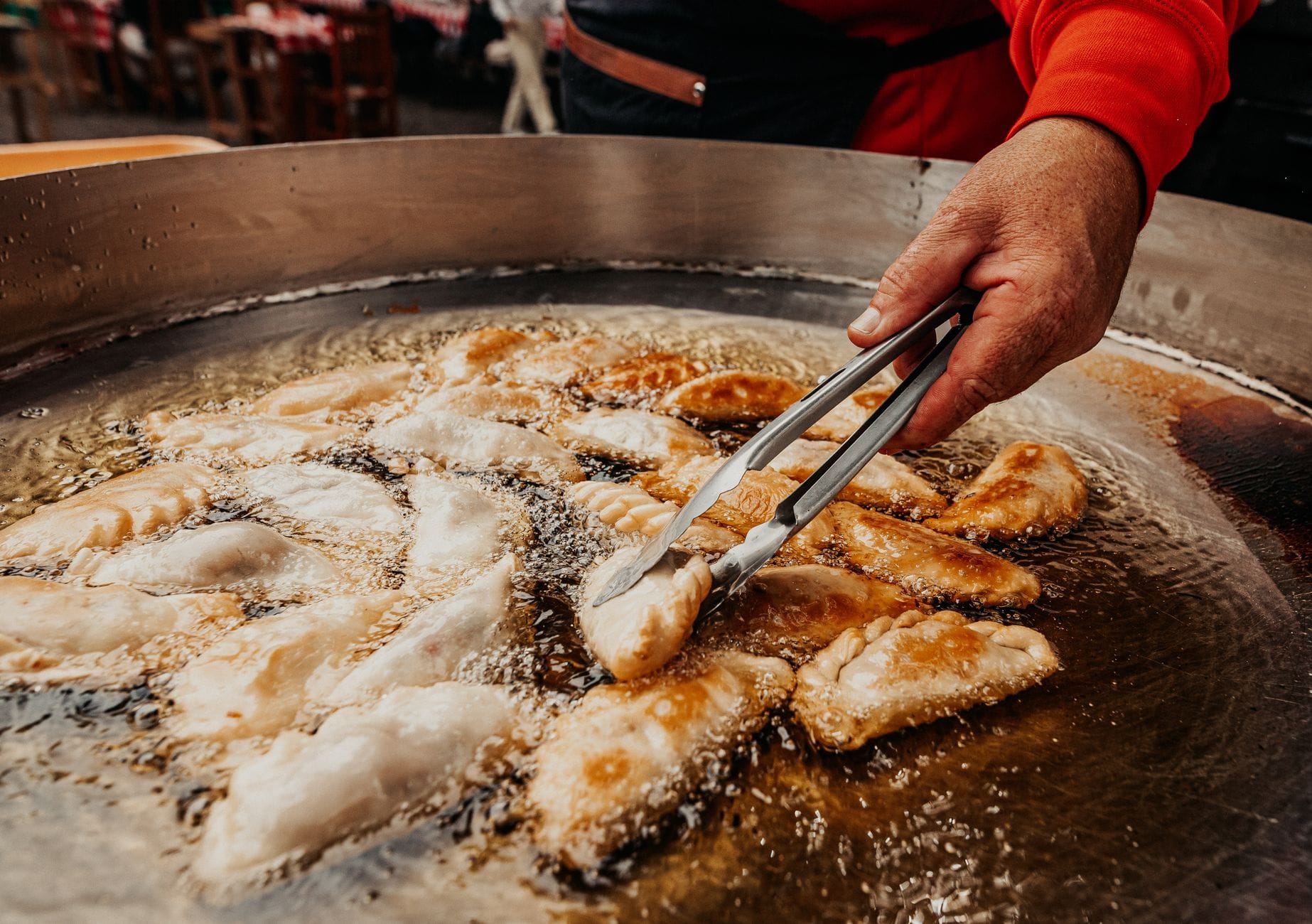 Empanadas smażące się w gorącym oleju, zbliżenie ulicznego jedzenia