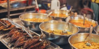 Od pierwszego garnka curry do kultowego stoiska na rogu ulicy miasta Kolorowe dania azjatyckiego street foodu w metalowych miskach na straganie
