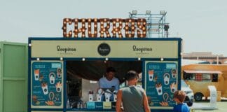Jak zrobić prawdziwe churros z food trucka: idealne ciasto, smażenie i tajemnica gęstego sosu czekoladowego Ojciec i syn zamawiają churros na targowym stoisku w Dubaju