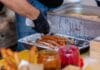 Ciepłe dania w ruchu na chłodne dni: od koreańskich placków po tureckie gözleme Zbliżenie na ulicznego sprzedawcę przygotowującego churros z dodatkami