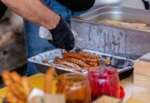 Ciepłe dania w ruchu na chłodne dni: od koreańskich placków po tureckie gözleme Zbliżenie na ulicznego sprzedawcę przygotowującego churros z dodatkami