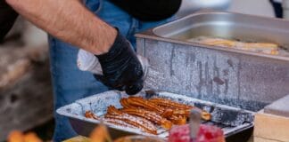 Ciepłe dania w ruchu na chłodne dni: od koreańskich placków po tureckie gözleme Zbliżenie na ulicznego sprzedawcę przygotowującego churros z dodatkami
