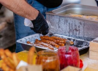Zbliżenie na ulicznego sprzedawcę przygotowującego churros z dodatkami