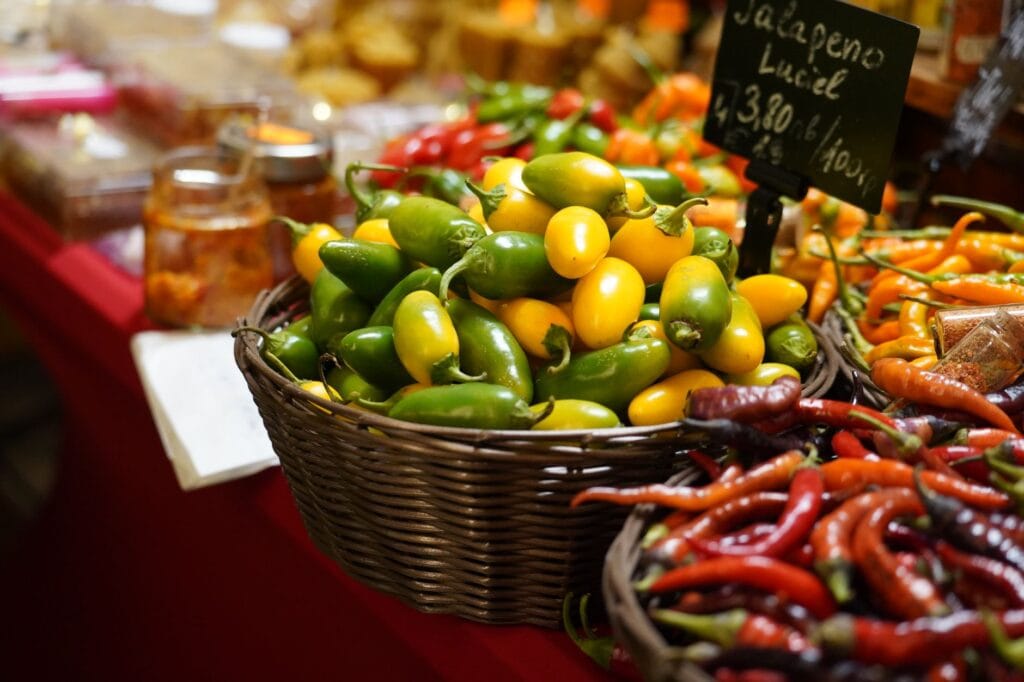 Kosz kolorowych papryczek jalapeño i chili na targowym stoisku